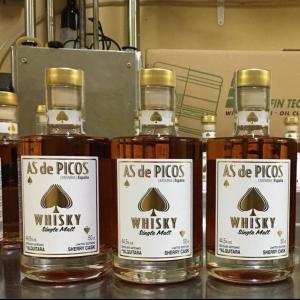 a group of three bottles of whisky on a shelf at Apartamentos Calm & Nature - Adults Only in Cabezón de Liébana +55 photos