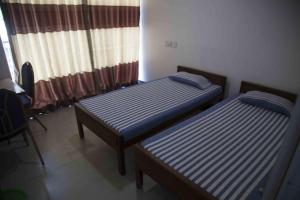 2 camas individuales en una habitación con ventana en Lodge in 611, en Kandy