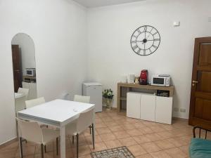 a kitchen with a table and chairs and a clock on the wall at A Casa di Luca in Campagna