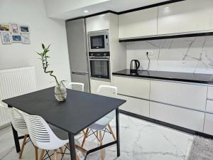 a kitchen with a black table and white appliances at GREY LUXURY HOUSE in Ipsos