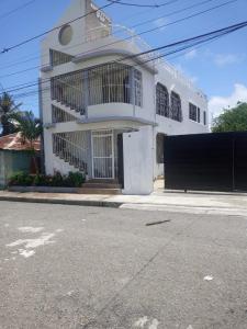 a white house on the side of a street at APARTAMENTOS IPAP LUPERON in Puerto de Luperon