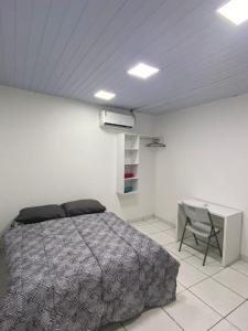 a bedroom with a bed and a desk in it at Apartamento grande para família ou amigos in Boa Vista