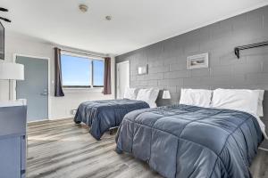 1 dormitorio con 2 camas y ventana en Cape View Motel & Cottages en Mavillette