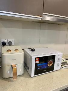 a microwave sitting on a kitchen counter next to a toaster at KLCC View by Regalia Dorms in Kuala Lumpur