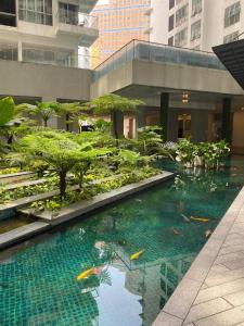 a pool of water in a building with trees at KLCC View by Regalia Dorms in Kuala Lumpur