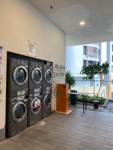 a laundry room with four washing machines in a building at KLCC View by Regalia Dorms in Kuala Lumpur
