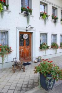 a front door of a white building with flowering plants at Ferienwohnung Dürrenroth in Dürrenroth