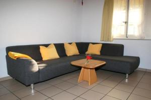 a black couch with yellow pillows and a coffee table at Ferienwohnung Dürrenroth in Dürrenroth