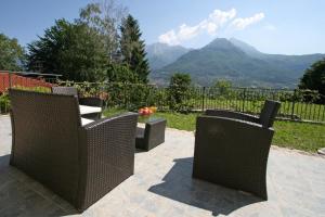 3 Korbstühle und ein Tisch mit Bergblick in der Unterkunft Ferienhaus in Onno mit Grill, Terrasse und Garten in Onno
