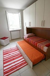 Zimmer mit 2 Betten, weißen Schränken und einem roten Teppich in der Unterkunft Ferienhaus in Onno mit Grill, Terrasse und Garten in Onno