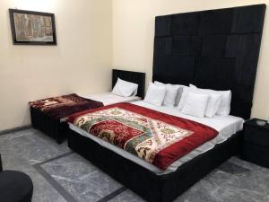 een slaapkamer met 2 bedden in een kamer bij Hotel Royal inn in Lahore