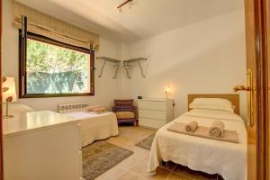 a bedroom with two beds and a tub and a sink at Montgrí 27 in Palafrugell +16 photos