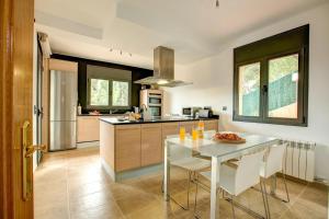 a kitchen with a white table and white chairs at Montgrí 27 in Palafrugell