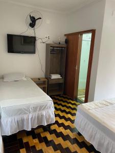 um quarto de hotel com duas camas e uma ventoinha em Hotel pousada Krone Praia de Iracema Fortaleza em Fortaleza