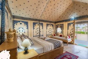 una camera da letto con un letto con carta da parati blu e bianca di THE KINGS RESORT a Jaisalmer