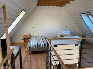 a bedroom with a bed and a desk in a attic at Maison de Kermouster, juste avant le Paradis in Lézardrieux