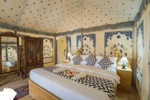 una camera da letto con un grande letto con carta da parati blu e bianca di THE KINGS RESORT a Jaisalmer