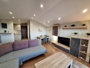 sala de estar con sofá y TV en Luxury suite with sea and Olympus view, en Leptokarya