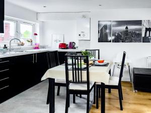 Charming London Home, Opp Arnos Grove Underground Station في New Southgate: مطبخ مع طاولة وكراسي في مطبخ