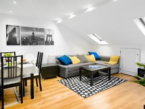 Charming London Home, Opp Arnos Grove Underground Station في New Southgate: غرفة معيشة مع أريكة وطاولة
