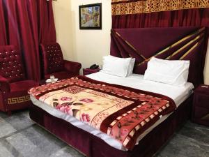 een slaapkamer met een bed en een stoel bij Hotel Royal inn in Lahore