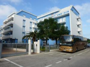 ein Bus, der auf einem Parkplatz vor einem Gebäude parkt in der Unterkunft Ferienwohnung in Cupra Marittima mit gemeinsamem Pool in Cupra Marittima