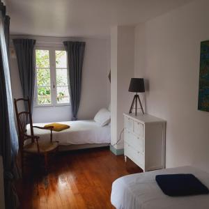 Châteauneuf-sur-Charente的住宿－Annexe du pont de la Charente，一间卧室设有两张床和窗户。