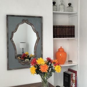 a vase of flowers in front of a mirror at Annexe du pont de la Charente Côté jardin in Châteauneuf-sur-Charente +3 photos