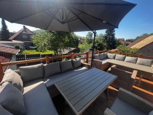 a patio with a wooden table and an umbrella at Haus der Möglichkeiten 12 Personen Außensauna in Barbis
