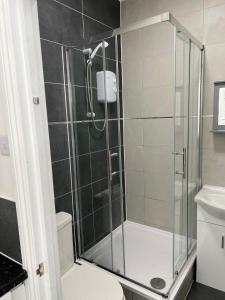 W łazience znajduje się prysznic ze szklanymi drzwiami. w obiekcie Starlet Property w mieście Wanstead