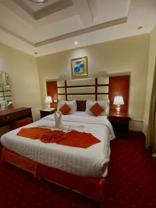 um quarto de hotel com uma cama grande e duas lâmpadas em فندق زهرة الربيع zahrat alrabie Hotel em Jeddah