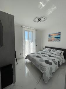 a white bedroom with a bed and a window at OrizzonteMare in Ortona