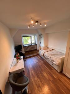 Schlafzimmer mit einem Bett, einem Schreibtisch und einem Fenster in der Unterkunft Ihr Zuhause über den Wolken in Berlin