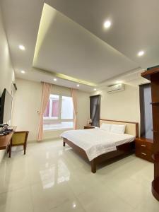um quarto com uma cama, uma secretária e uma televisão em Villa Sao Biển SB14 FLC Sầm Sơn em Sam Son