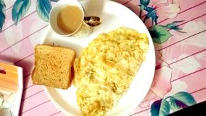 a plate with eggs and toast and a cup of coffee at Hotel Orchid in Kalimpong