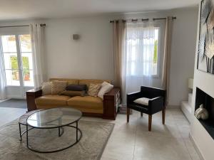 a living room with a couch and a table at PERNO LI FONT villa contemporaine avec piscine in Pernes-les-Fontaines