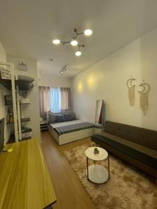 a living room with a couch and a bed and a table at CONDO IN LAPU LAPU NEAR AIRPORT in Lapu Lapu City