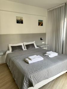 een slaapkamer met een groot bed en 2 handdoeken bij Fantastic Apartment 163 in Finikoudes in Larnaka