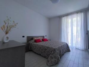 um quarto com uma cama com duas almofadas vermelhas em STAY & SAIL - apartment em Torri del Benaco