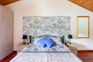 1 dormitorio con 1 cama grande con almohadas azules en Rifugio sul Lago di Lugano a Porto Ceresio en Porto Ceresio