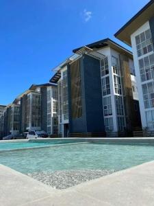 a swimming pool in front of a large building at CONDO IN LAPU LAPU NEAR AIRPORT in Lapu Lapu City