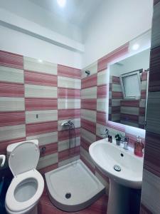La salle de bains est pourvue de toilettes et d'un lavabo. dans l'établissement Guesthouse Dollomaja Ksamil, à Ksamil