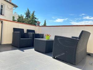 - un ensemble de chaises et d'une table sur une terrasse dans l'établissement L'ensoleillée Appartement Maison privé Cannes, à Cannes