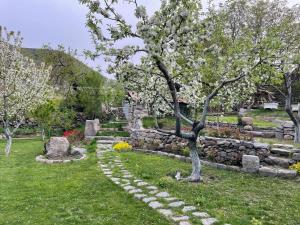 a garden with a tree and a stone wall at Hin Tun in Artabuynkʼ