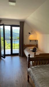 a bedroom with two beds and a large window at Vila Zapis in Pirot
