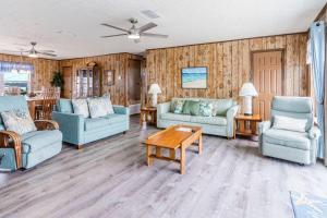 a living room with blue couches and a table at Klitzke House in Gulf Shores