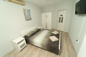 ブルガスにあるСлънце и море Бургасの白いベッドルーム(ベッド1台、テレビ付)