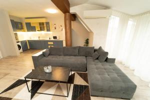 Sala de estar con sofá gris y mesa en Слънце и море Бургас en Burgas