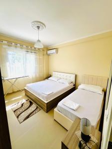 1 Schlafzimmer mit 2 Betten, einem Tisch und einem Fenster in der Unterkunft N&E Apartment in Durres in Durrës