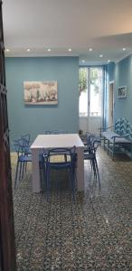 een tafel en stoelen in een kamer met een blauwe muur bij Appartamento Ibisco in Recco